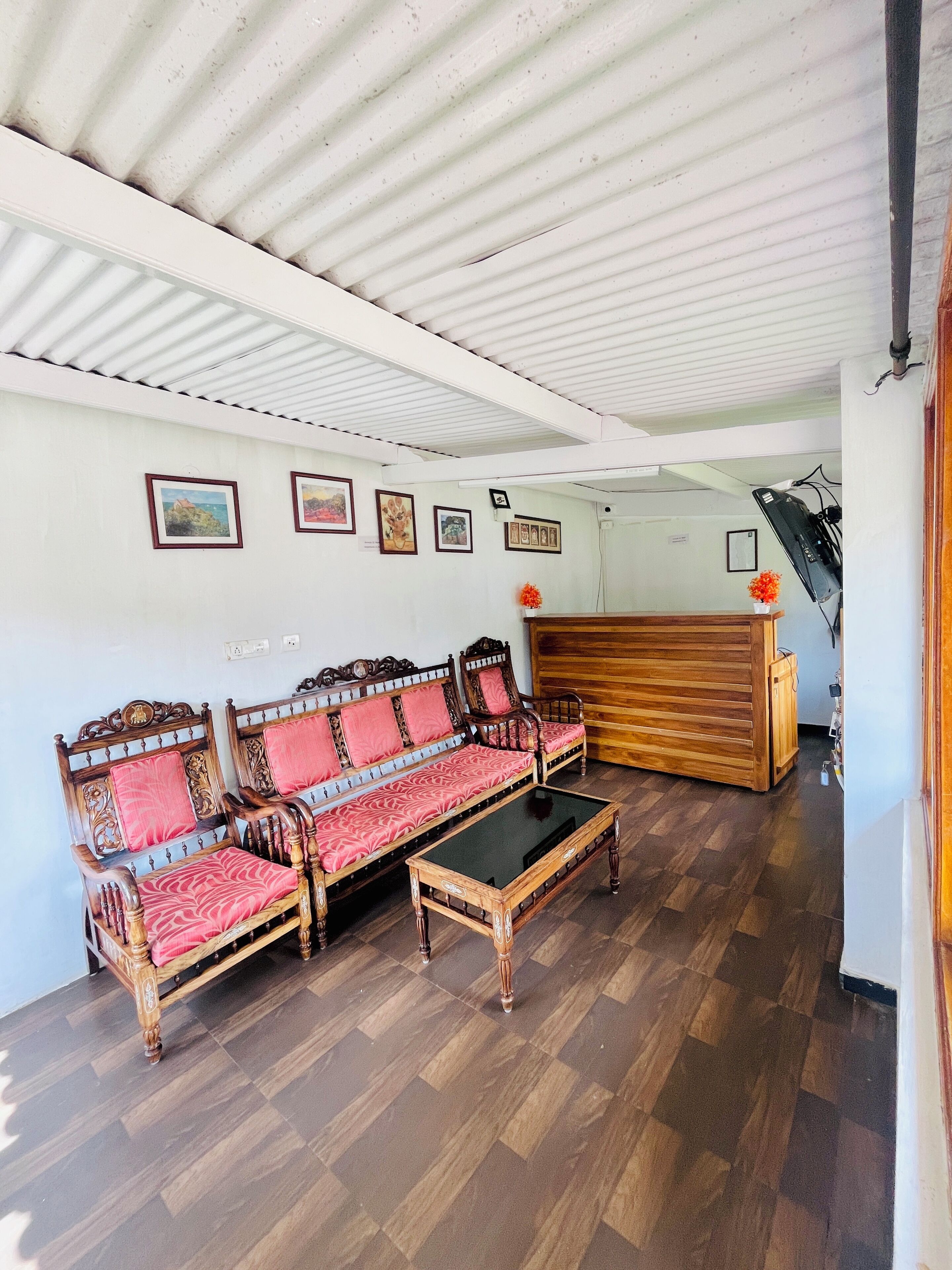 A room with a wooden sofa set, a coffee table, and a wooden cabinet.