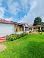 A traditional house with a red-tiled roof, a white exterior, and a well-maintained garden.