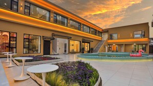 A modern hotel courtyard with a pool, outdoor seating, and a staircase leading to the upper floor. - Chuxin Moshe Hotel (Shanghai)