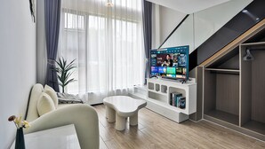 A modern living room with a sofa, a coffee table, a TV, and a staircase. - Chuxin Moshe Hotel (Shanghai)