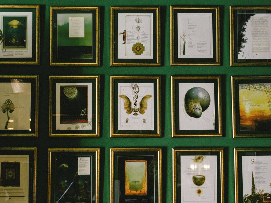 Una pared decorada con ilustraciones botánicas enmarcadas y certificados.