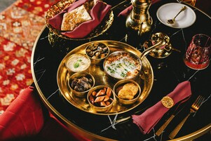 A luxurious dining table with a variety of dishes, including a bowl of soup, a plate of bread, and several side dishes.