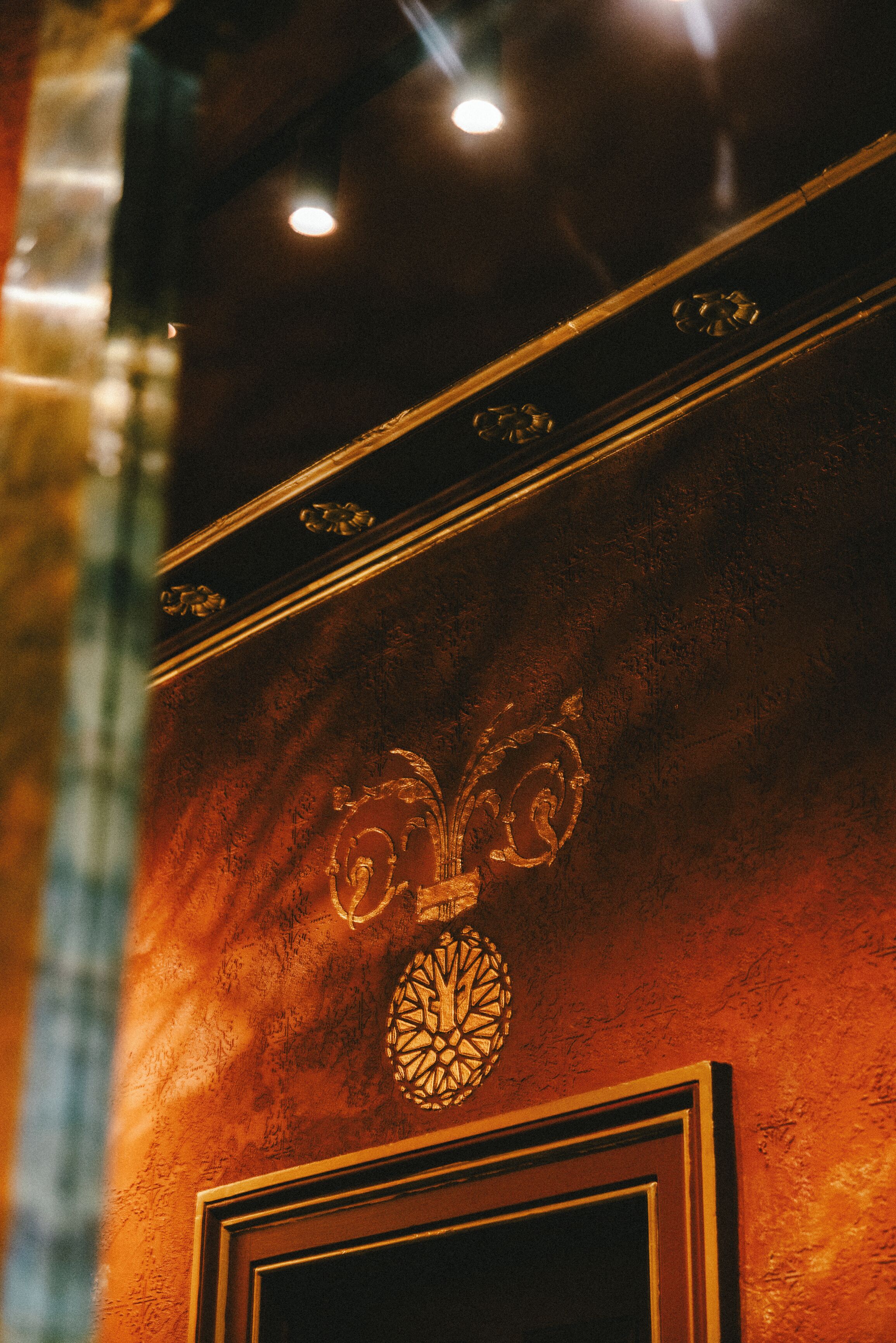 A wall with a decorative emblem and a framed picture.