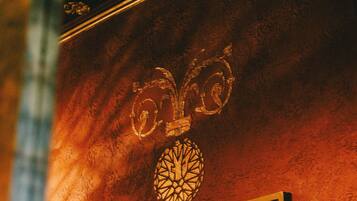 A wall with a decorative emblem and a framed picture.