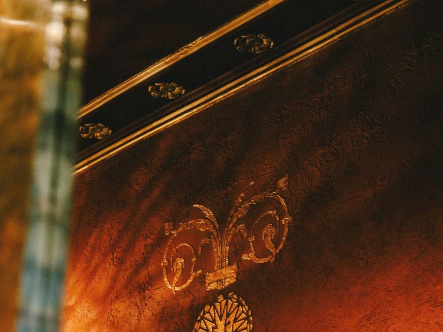 A wall with a decorative emblem and a framed picture.