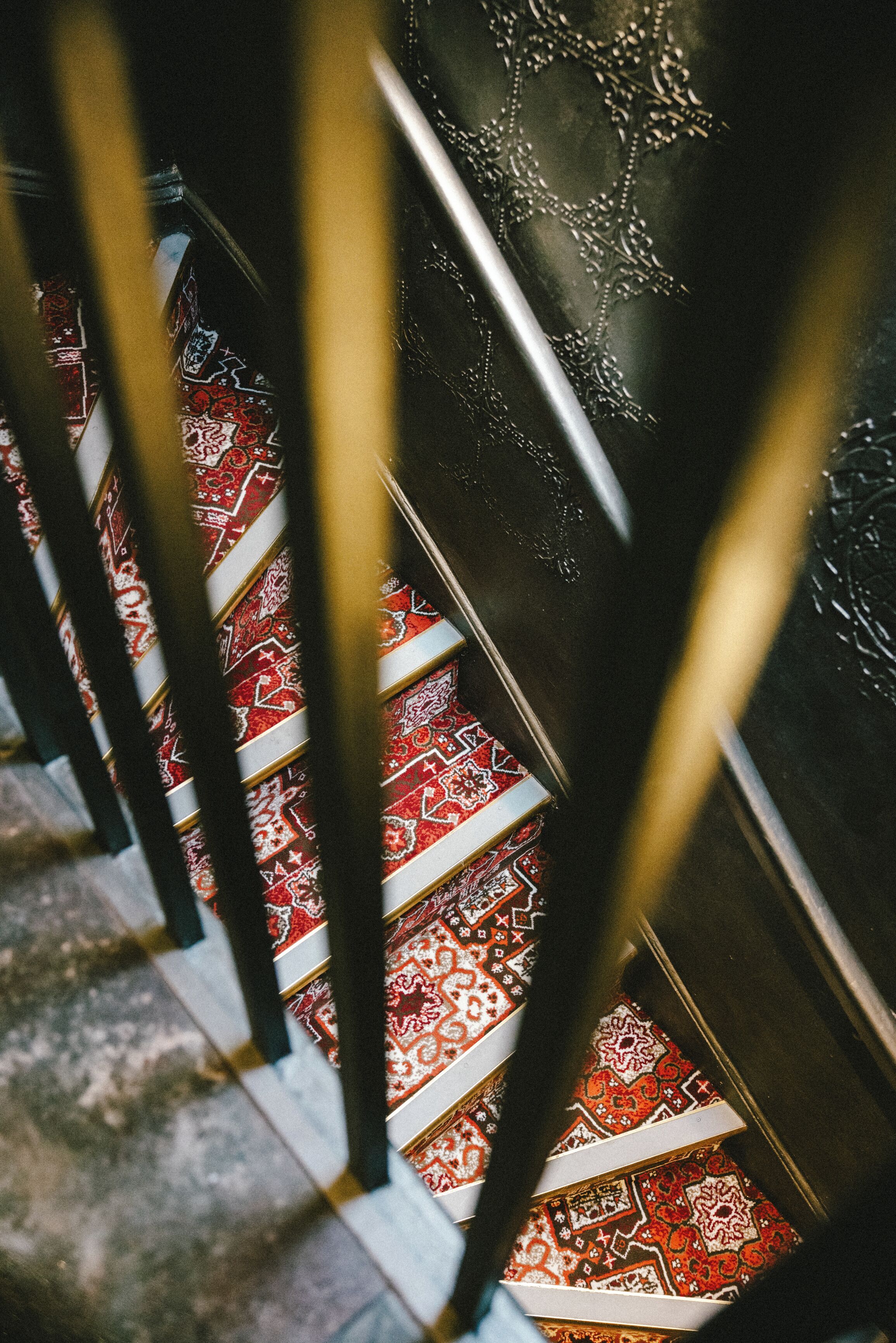 A staircase with ornate metal railings and patterned carpet.
