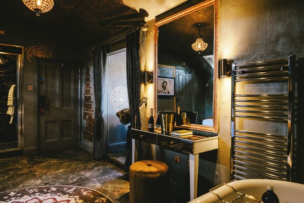 A dimly lit hallway with a vintage aesthetic, featuring a mirror, a radiator, and a patterned rug. - Baloci (Birmingham)