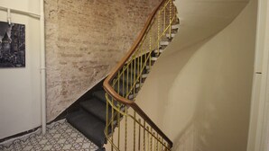 Een trap met een bakstenen muur en een gele leuning.