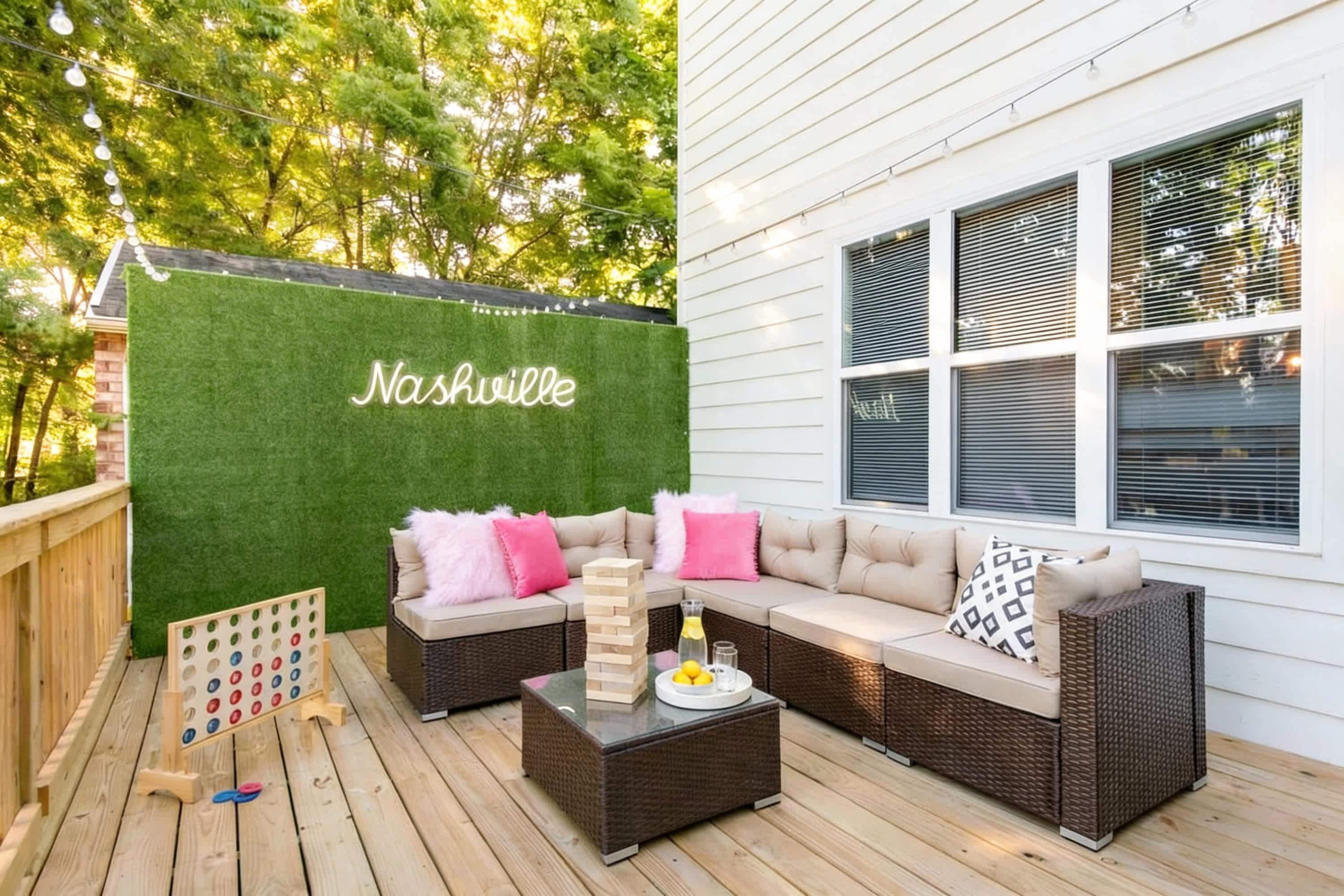 A deck with outdoor furniture, a board game, and a green wall with the word 'Nashville' on it.