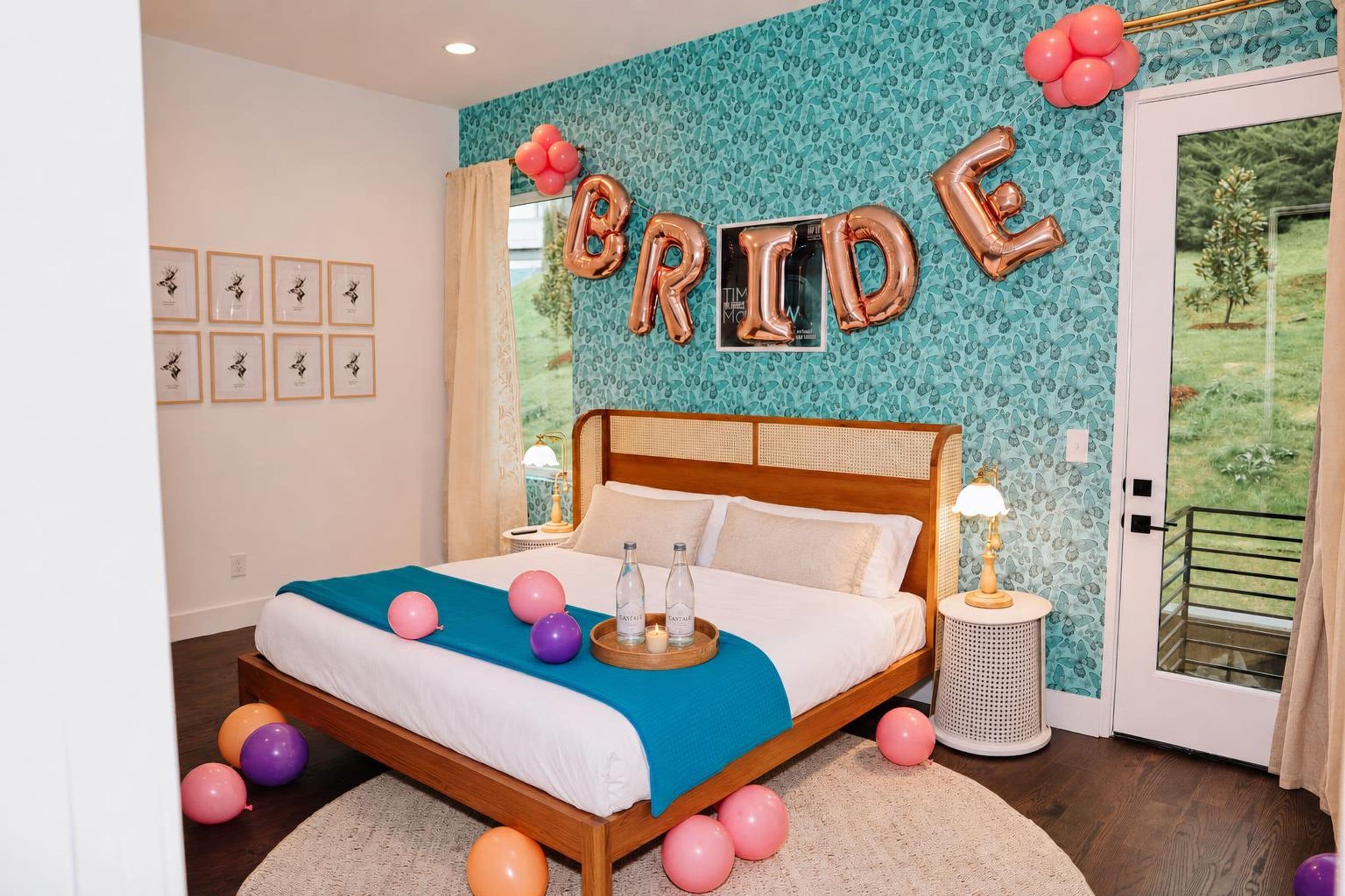 A bedroom with a bed, a window, and a wall with balloons spelling 'BRIDE'.