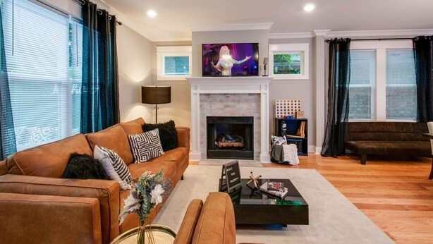 A living room with a fireplace, a sofa, a coffee table, and a television. - Booking Fast 12 Beds-large Yard (Nashville)