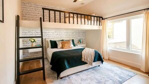 A bedroom with a bunk bed, a ceiling fan, a window with curtains, and a wooden floor. - Close to the Gulch - Book Today (Nashville)
