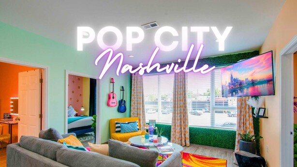 A modern living room with a sofa, a coffee table, and a TV. - NEW 4 Bedroom Apt Near DT Walk to Restaurants (Nashville)