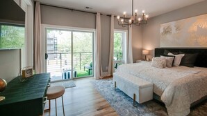 A bedroom with a large bed, a desk, and a view of a balcony. - Large Group Lux 3mi Downtown - Rooftop City Views (Nashville)