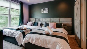 A double bed with a headboard, a bedside table with a candle, and a window with curtains. - Close to the Gulch - Book Today (Nashville)