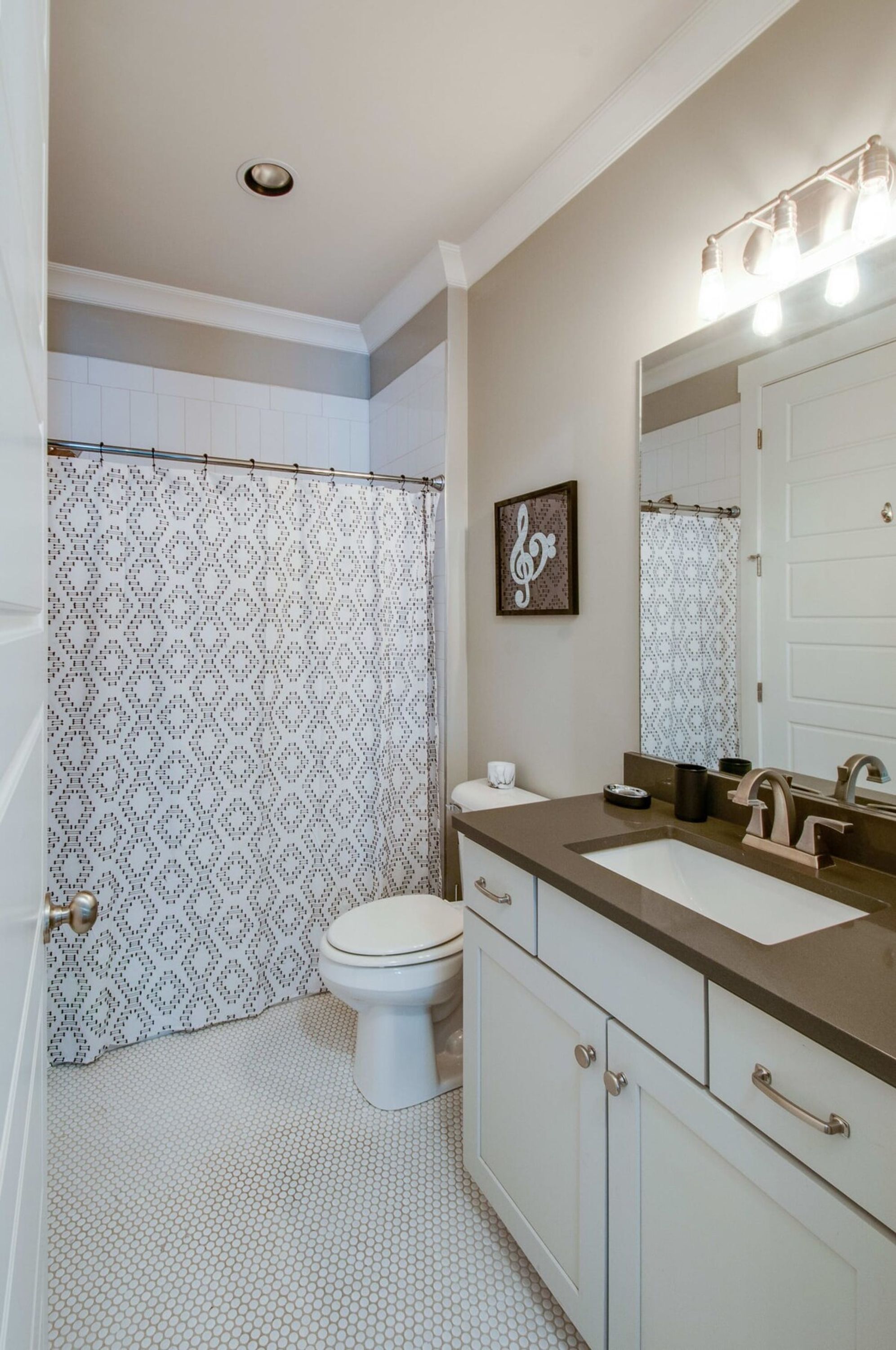 Une salle de bain équip ée de toilettes, d’un lavabo et d’un rideau de douche.
