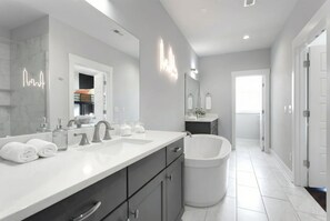 A modern bathroom with a large mirror, two sinks, a bathtub, and a walk-in shower. - Near Gulch 12 South Book Luxury Now (Nashville)
