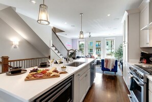 Una cocina moderna con una isla central, electrodomésticos de acero inoxidable y vistas a un balcón.