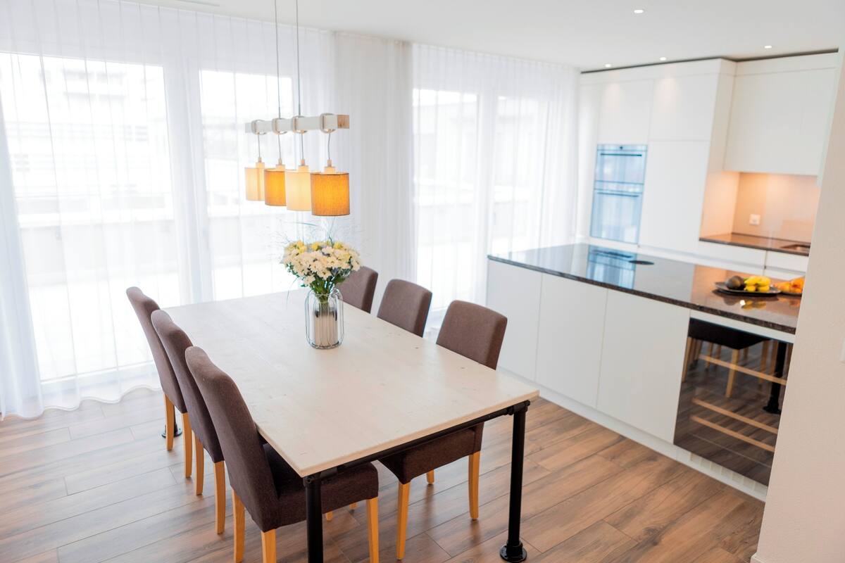 A modern kitchen with white cabinets and a wooden countertop.