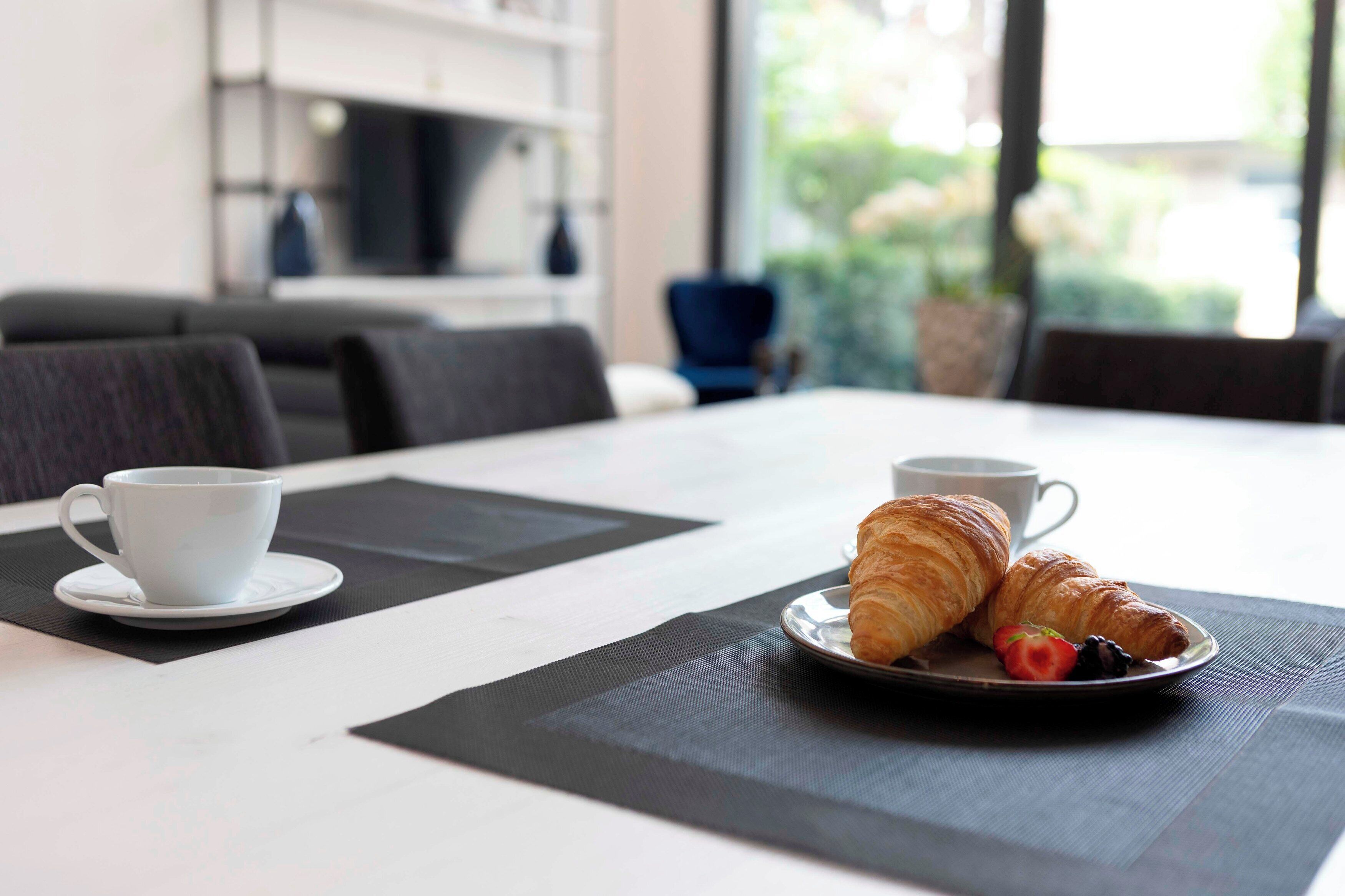 Colazione con croissant e una tazza di caffè su un tavolo.