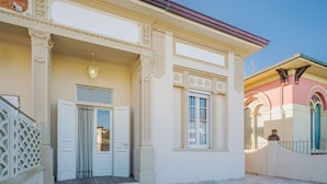 A building with a hexagonal tiled courtyard, white doors, and a decorative entrance with columns. - Beautiful  villa for 5 people with WIFI, A/C, TV and patio (Camaiore)