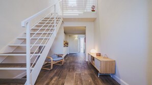 A modern interior with a wooden staircase, a bench, and a wooden console table with a lamp. - Beautiful  villa for 5 people with WIFI, A/C, TV and patio (Camaiore)