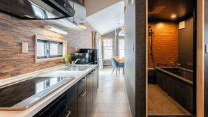 A modern kitchen with a built-in oven, a coffee machine, and a sink. - Myoko Onsen cottage Ajisai  (Myoko)