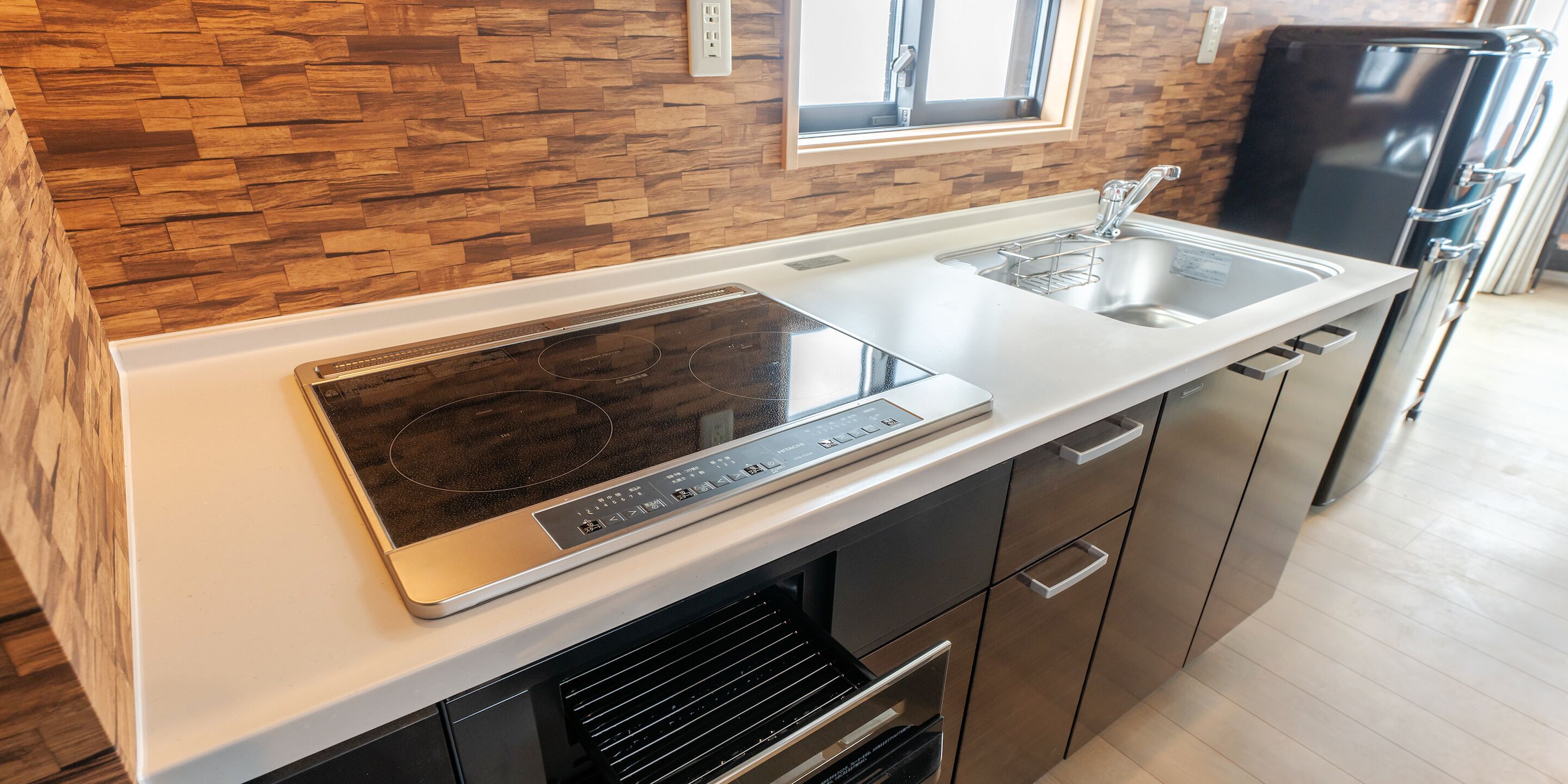 A modern kitchen with a built-in stove, a sink, and a refrigerator.