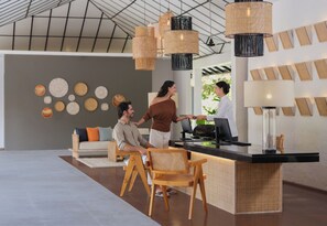 A reception area with a counter, wicker chairs, and a wall with circular wall art.