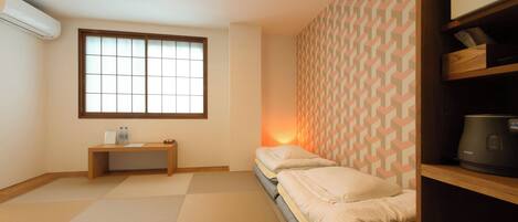 Una habitación pequeña y ordenada, con una cama, una mesita de noche, un calentador y una ventana con vistas.