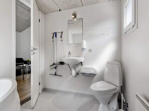 A modern bathroom with a toilet, sink, and shower area.