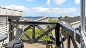 A balcony with a view of the sea, a metal railing, and a chair. - 6 Person Holiday Park Home in Faaborg (Faaborg)