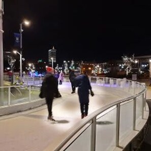 A nighttime pedestrian walkway with metal railings and street lamps. - 1 Bedroom Apartment Near Notre Dame 1309 5 (South Bend)