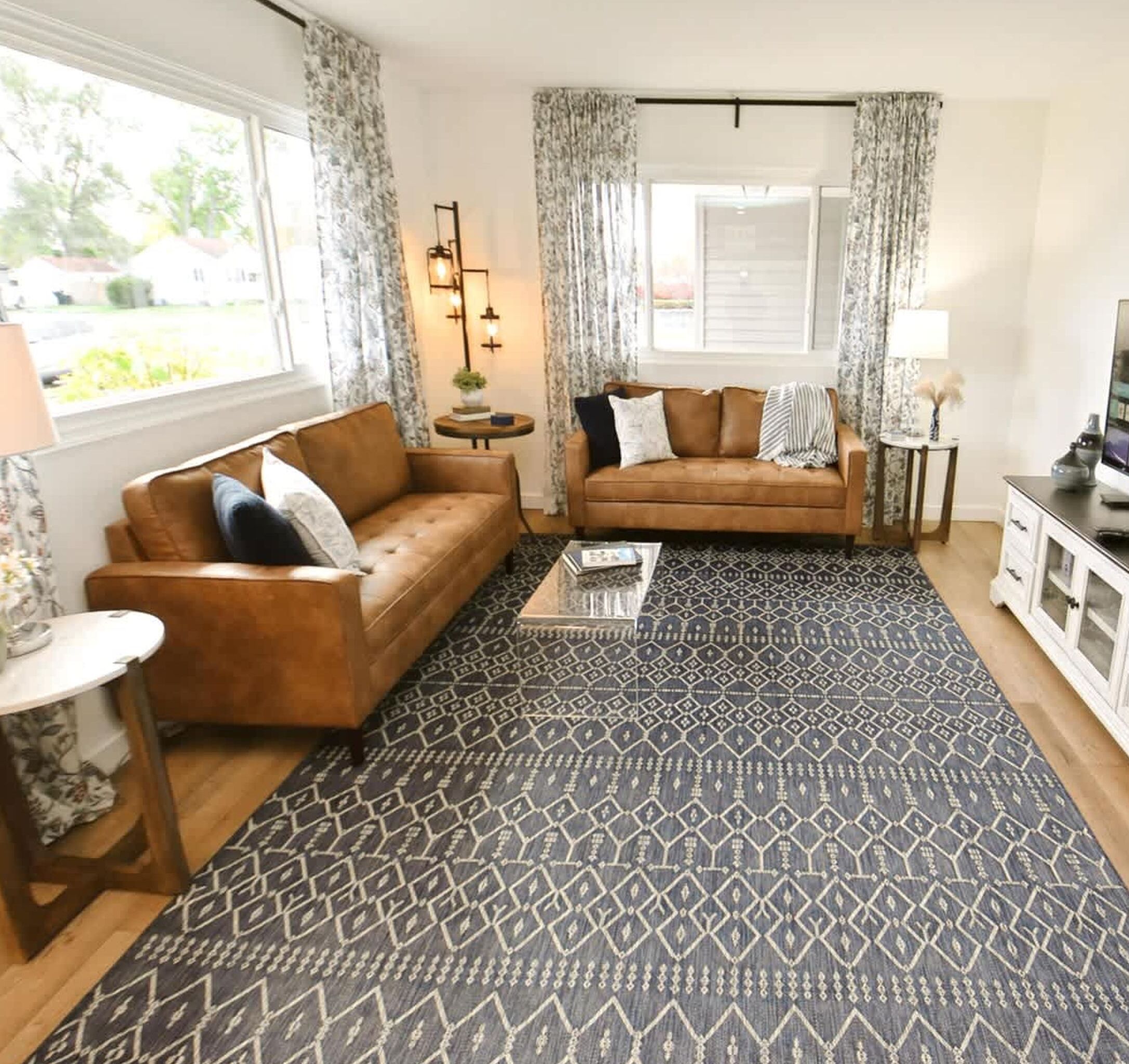 A living room with two sofas, a coffee table, and a TV stand.