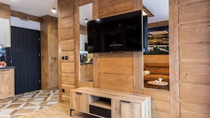 Una cocina moderna con paneles de madera, televisor de pantalla plana y un banco empotrado.