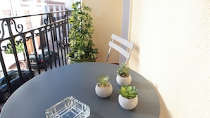 A round table with a clear glass object on it, surrounded by potted plants, on a balcony with a railing and a chair. - Molino suites, apt Ronda, two bedrooms en suite in the center of the city  (Ronda)