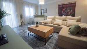 A living room with a beige sofa, a wooden coffee table, and a stone-patterned floor. - Molino suites, apt Ronda, two bedrooms en suite in the center of the city  (Ronda)