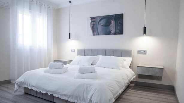 A modern bedroom with a large bed, white bedding, and two bedside tables with lamps. - Molino suites, apt Ronda, two bedrooms en suite in the center of the city  (Ronda)