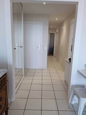 Stylish hallway leading to a room with a door and a small cabinet.