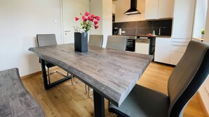 Une cuisine moderne avec des armoires blanches, un plan de travail en bois et une hotte noire.