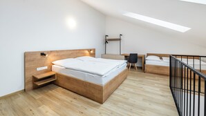Un dormitorio moderno con una cama de madera, un escritorio y una silla.