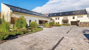 Una zona residencial moderna con paseos empedrados, paneles solares en los tejados y abundante vegetación cuidada.