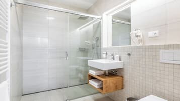 Apartamento com design assinado, varanda, vista para o pátio | Banheiro | Chuveiro, secador de cabelo, toalhas de banho, papel higiênico