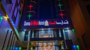 La façade de l’hôtel Sama Al-Misk, avec son enseigne lumineuse et ses éclairages décoratifs.