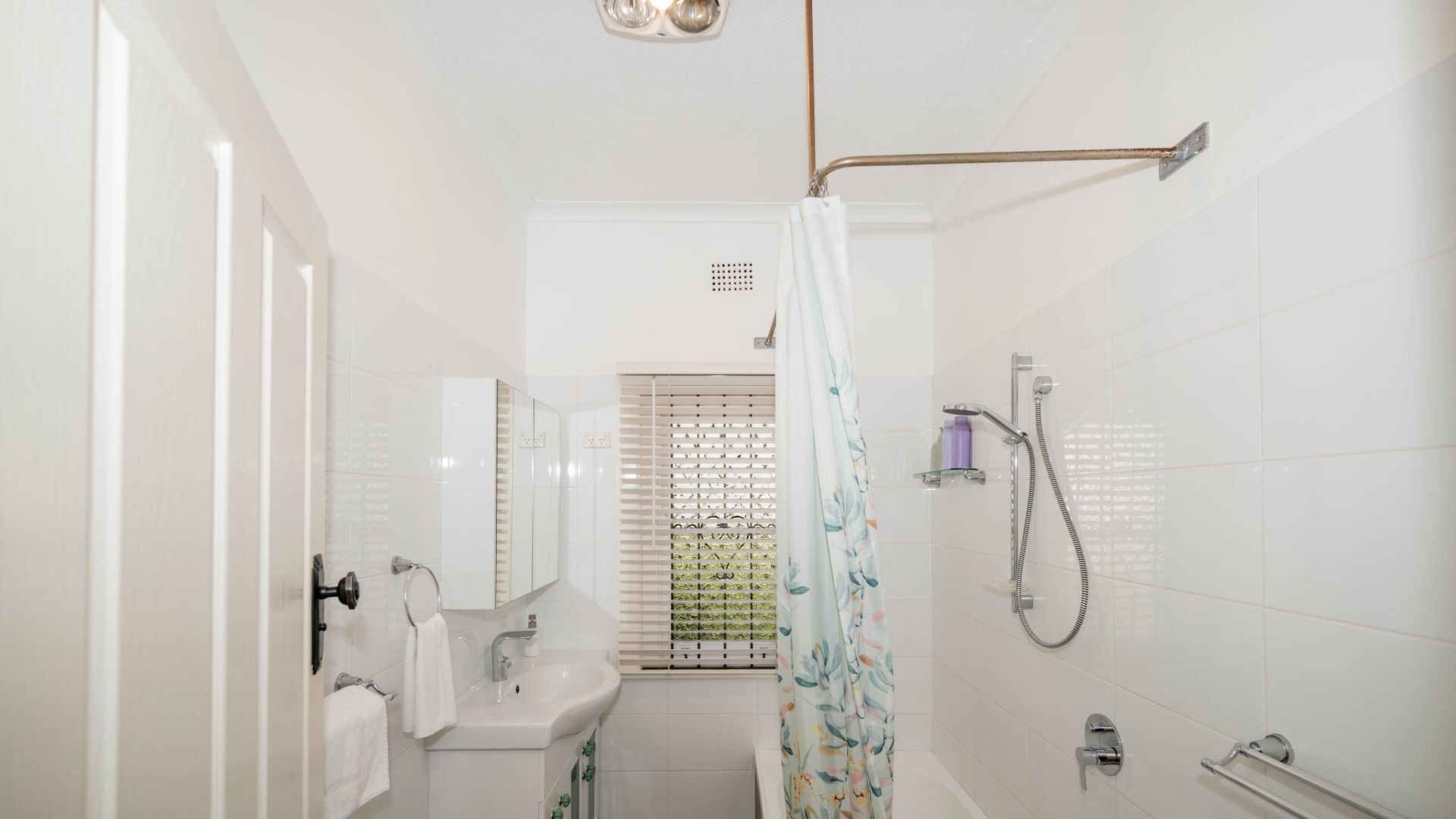 A modern bathroom with a shower, sink, and toilet.