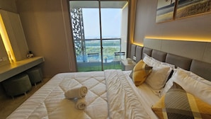 Camera d'albergo con un letto grande, una scrivania e vista su un balcone con posti a sedere.