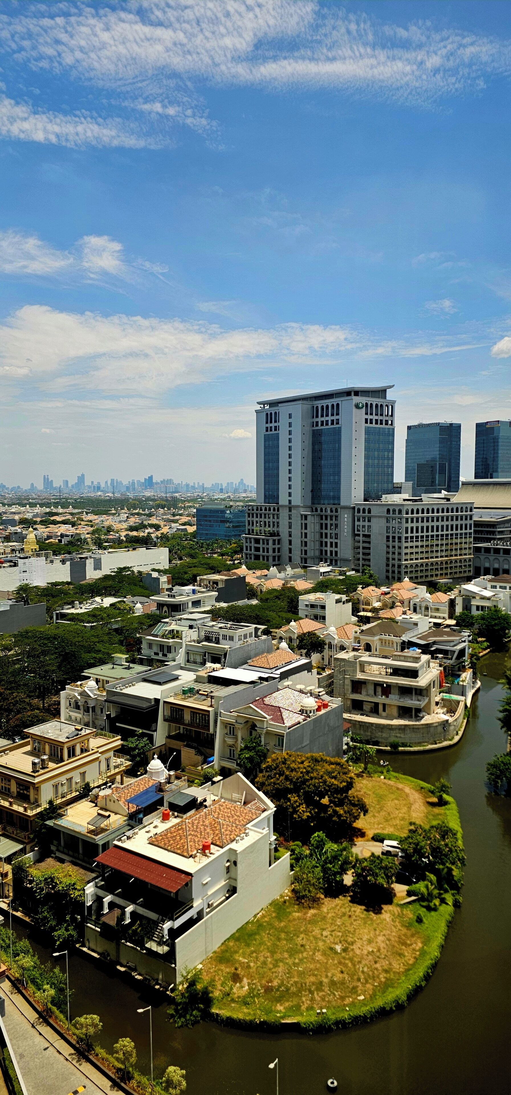 A river running through a city with modern buildings and a mix of residential and commercial structures.