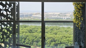 Una camera moderna con un'ampia porta-finestra che dà su un balcone. Il balcone presenta un tavolino rotondo con due sedie e una pianta in vaso.