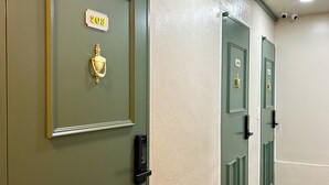 A hallway with green doors, each marked with a number. - Pocket Seoul (Seoul)