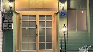 A hostel entrance with a wooden door, a bicycle parked outside, and a sign above the door. - Pocket Seoul (Seoul)